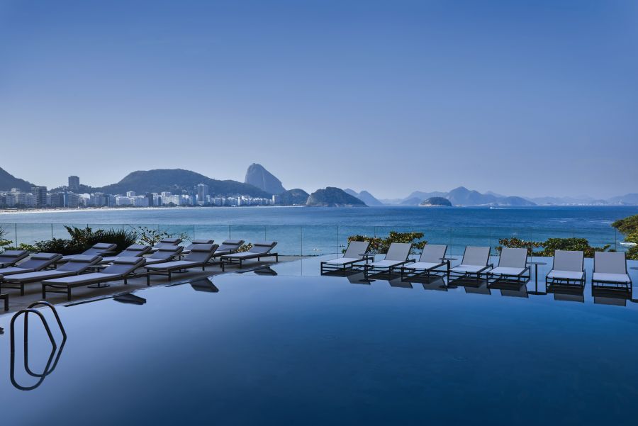 </who>The infinity pool at the Fairmont Copacabana flows toward the beach and Atlantic Ocean.